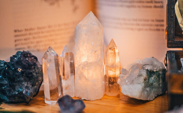 Clear and amethyst crystals glowing softly in warm light, symbolising the calming and restorative energy of crystal therapy.